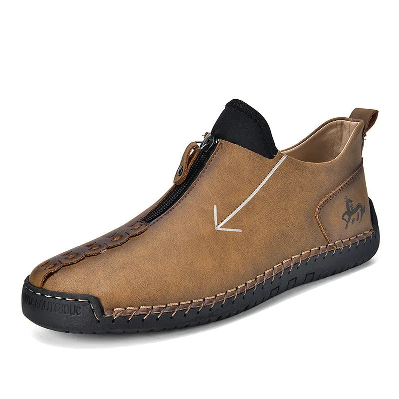 Men's black leather boots with a front zipper and round toe, showing hand-stitched sole detail.