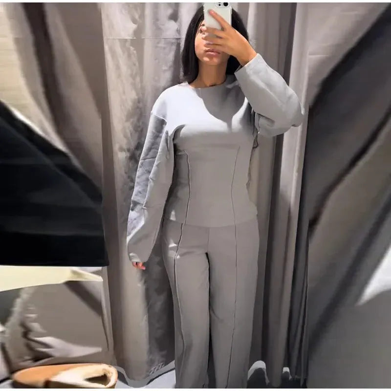 Women's apricot polar fleece suit set with long sleeve top and wide leg trousers on a hanger.