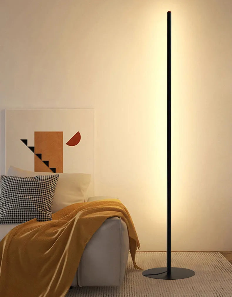 Simple modern vertical aluminium alloy floor lamp in silver, shown beside a sofa.