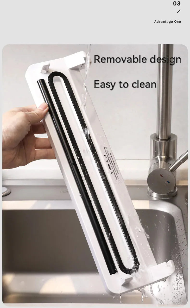 Black compact automatic vacuum sealing machine for home food preservation on a kitchen counter.