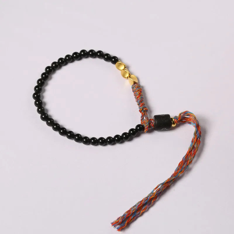 Hand-woven obsidian carrying strap bracelet showing textured weave and adjustable 15.5-16cm length
