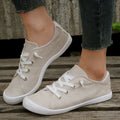 Women's creamy white low-top fabric sneakers with a casual design and rubber sole.