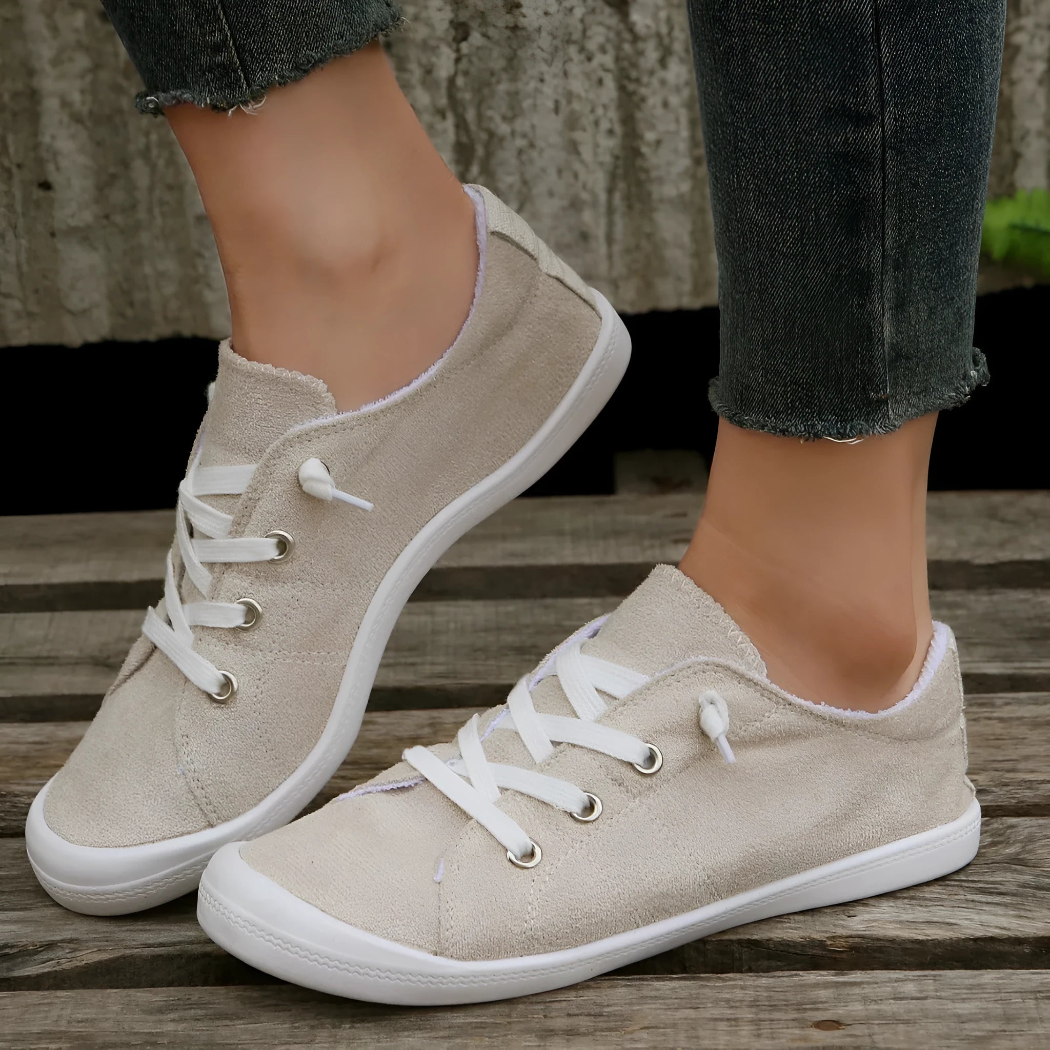 Women's creamy white low-top fabric sneakers with a casual design and rubber sole.