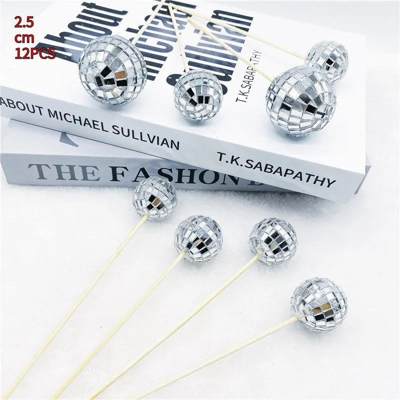 Glass disco ball cake decorations with wooden sticks in multiple sizes on birthday cake