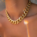 Gold-toned women's thick chain necklace with red accents, showing chunky 6cm wide links on a 32cm chain.
