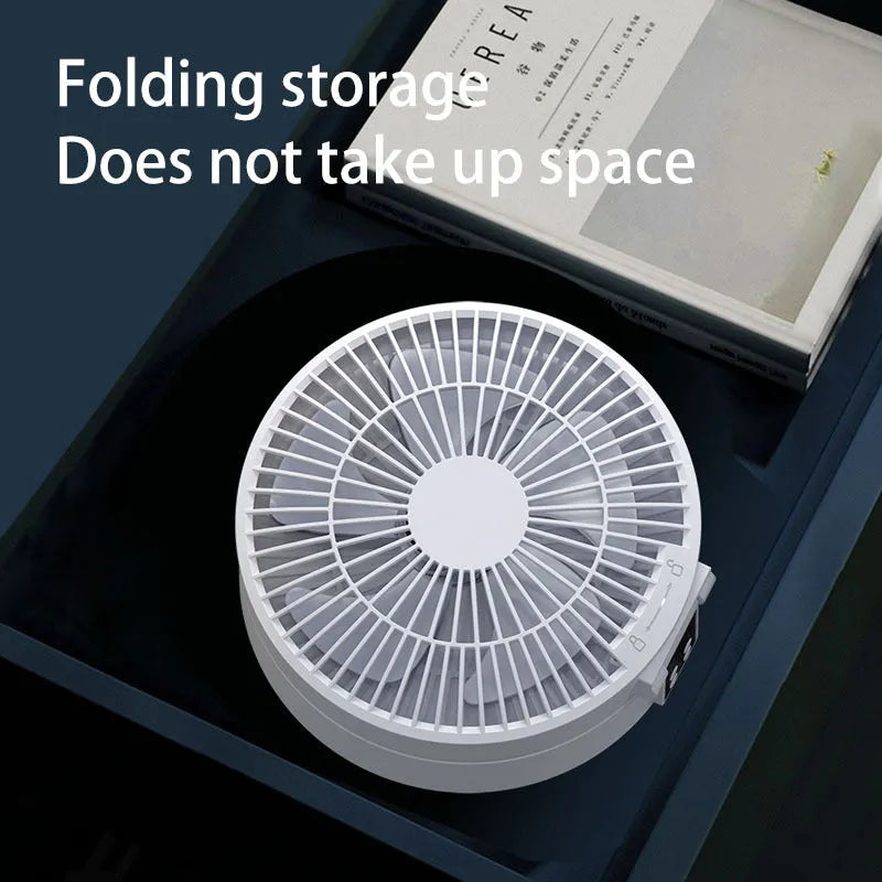 White portable USB rechargeable folding ceiling fan with remote control on desk
