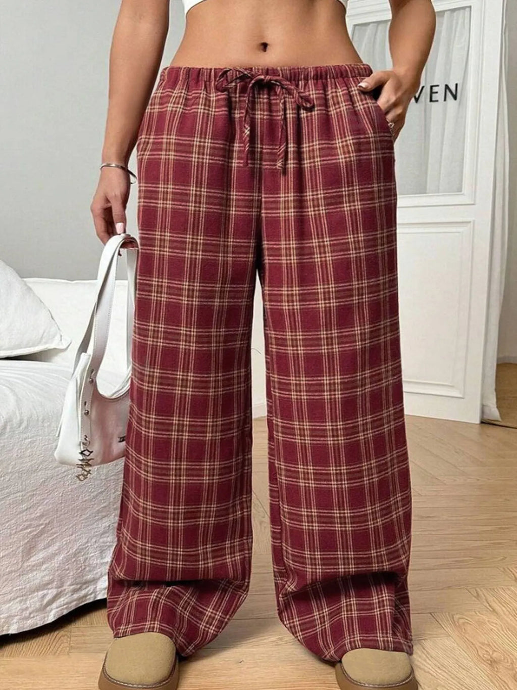 Women's red plaid loose trousers with drawstring waist and side pockets laid flat