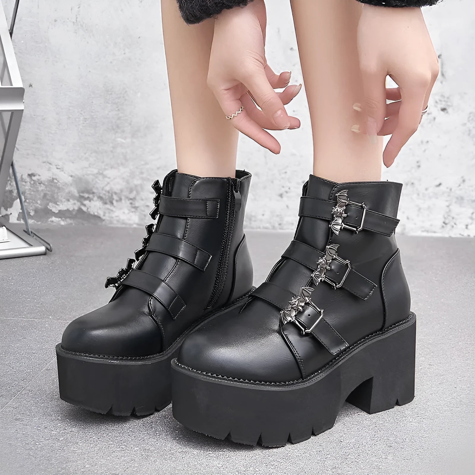 Black women's gothic punk ankle boots with a large bat-shaped buckle and a side zipper.