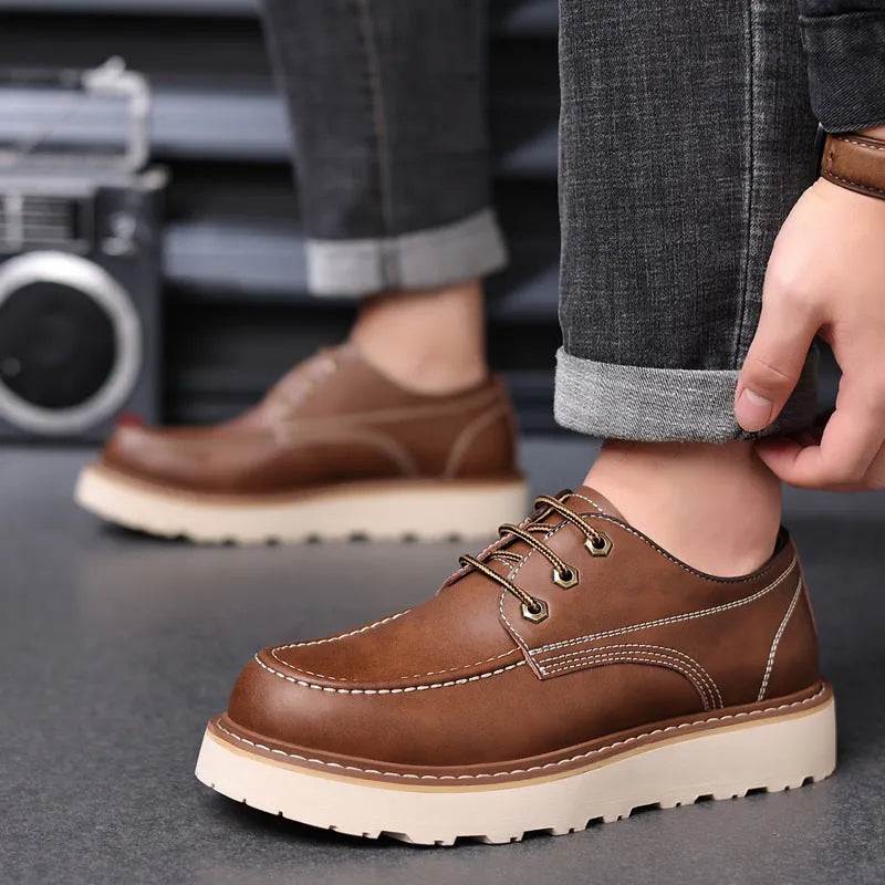 Men's black low-top Martin boots with round toe and rubber sole on a neutral background