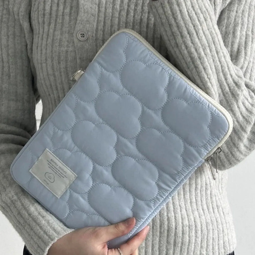 White cotton notebook storage bag with blue cloud embroidery on a table