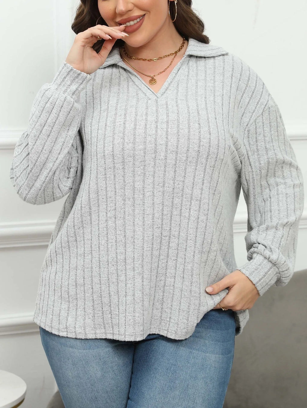 Plus size woman wearing a grey polo collar fleece pullover blouse with lantern sleeves.