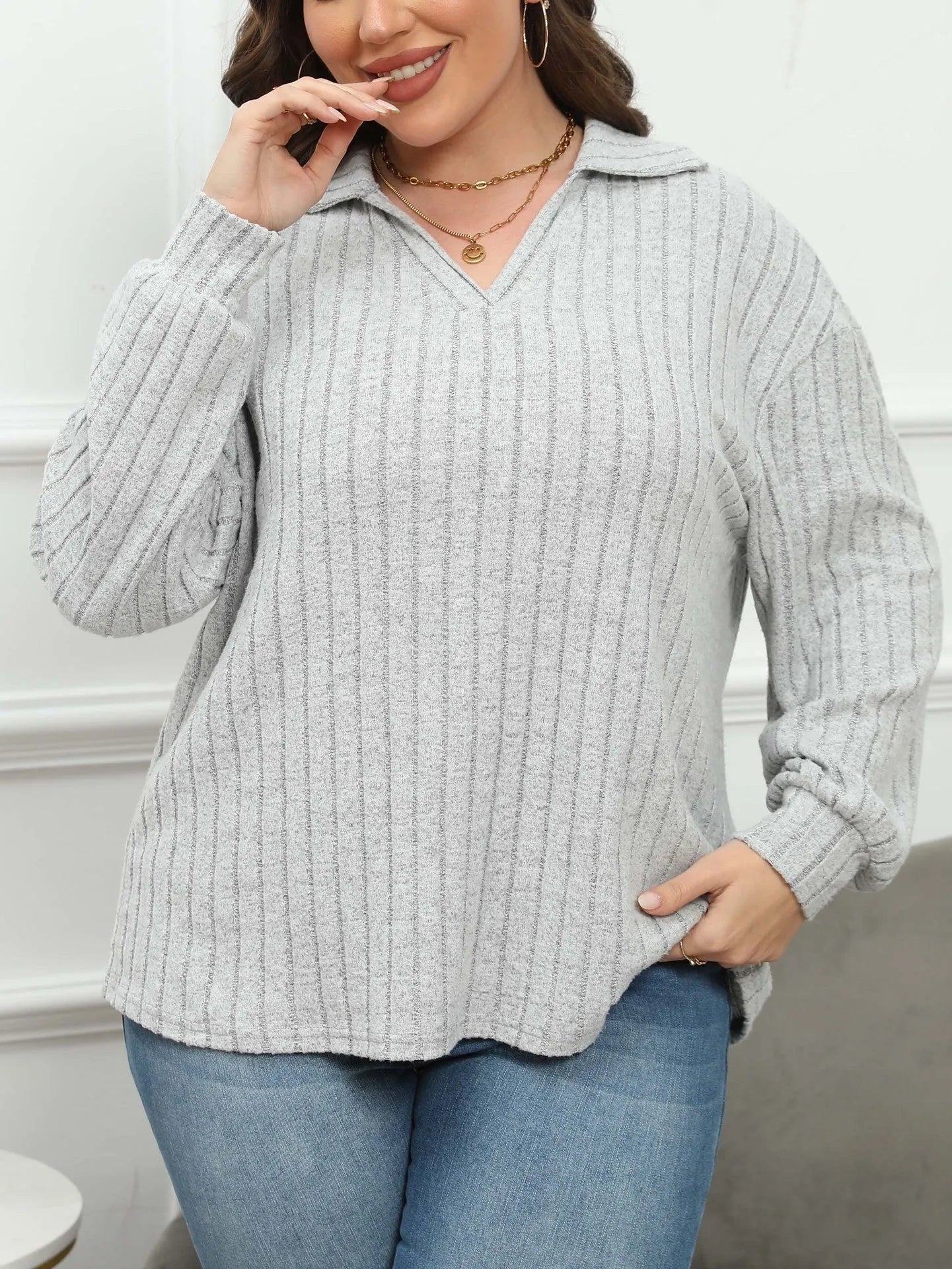 Plus size woman wearing a grey polo collar fleece pullover blouse with lantern sleeves.