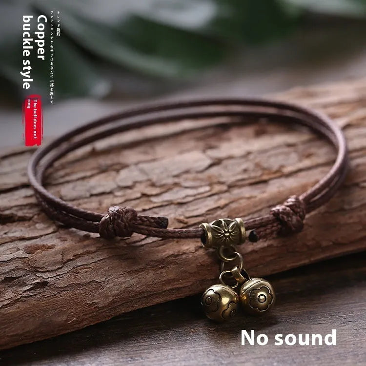 Small dog wearing adjustable nylon rope collar with brass bell in black, red, or coffee colour