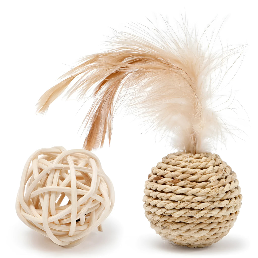 Two cat toys: a natural rattan ball with a bell and a colourful faux feather ball on a plain surface.