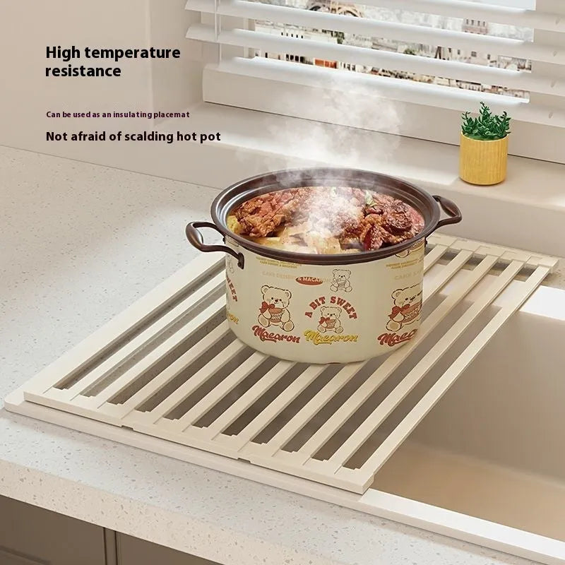 Milky white foldable stainless steel kitchen draining rack shown next to a sink.