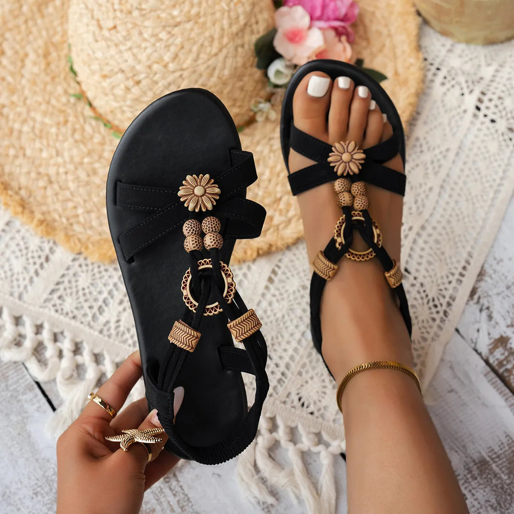 Black women's ethnic style flat beach sandals with beaded weave and rhinestone decorations.