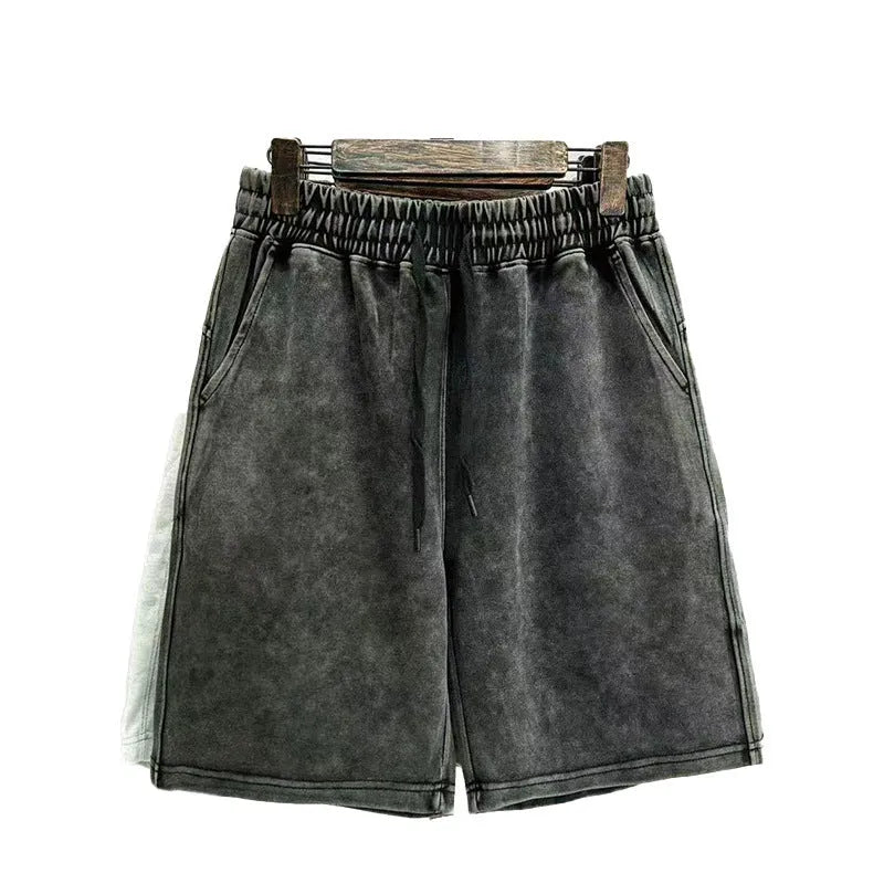 Men's charcoal black distressed denim shorts with straight leg and fifth pants length on a white background.