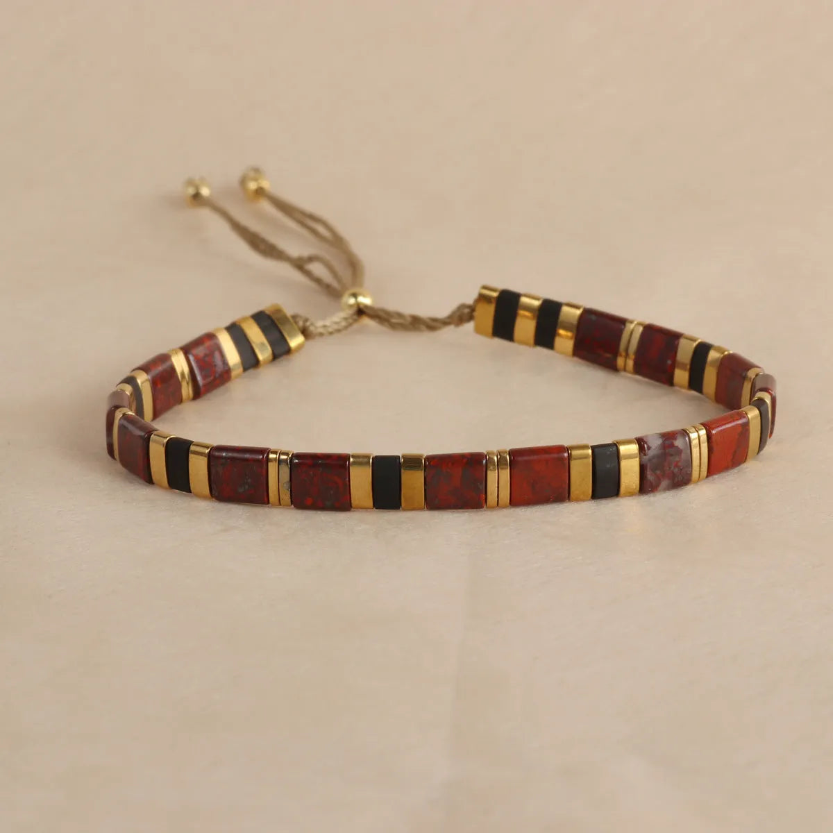 Adjustable pull beads bracelet with glass and coloured glaze beads in geometric and round shapes