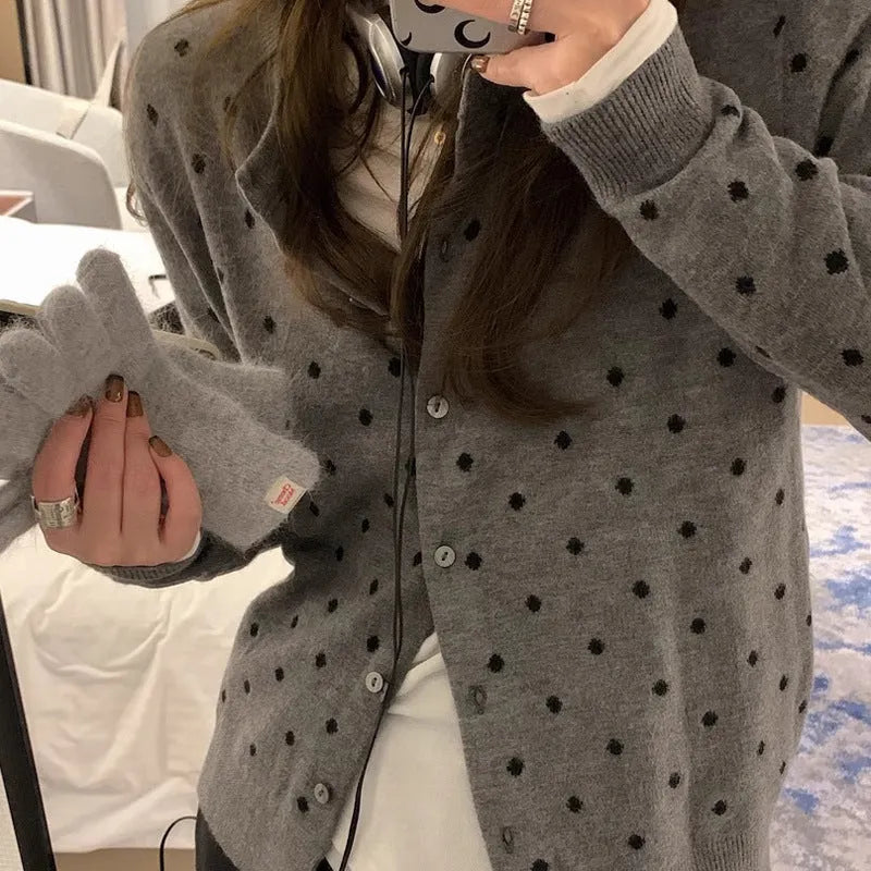 Grey dot knitted women's cardigan with crocheted flower details on the front.