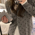 Grey dot knitted women's cardigan with crocheted flower details on the front.