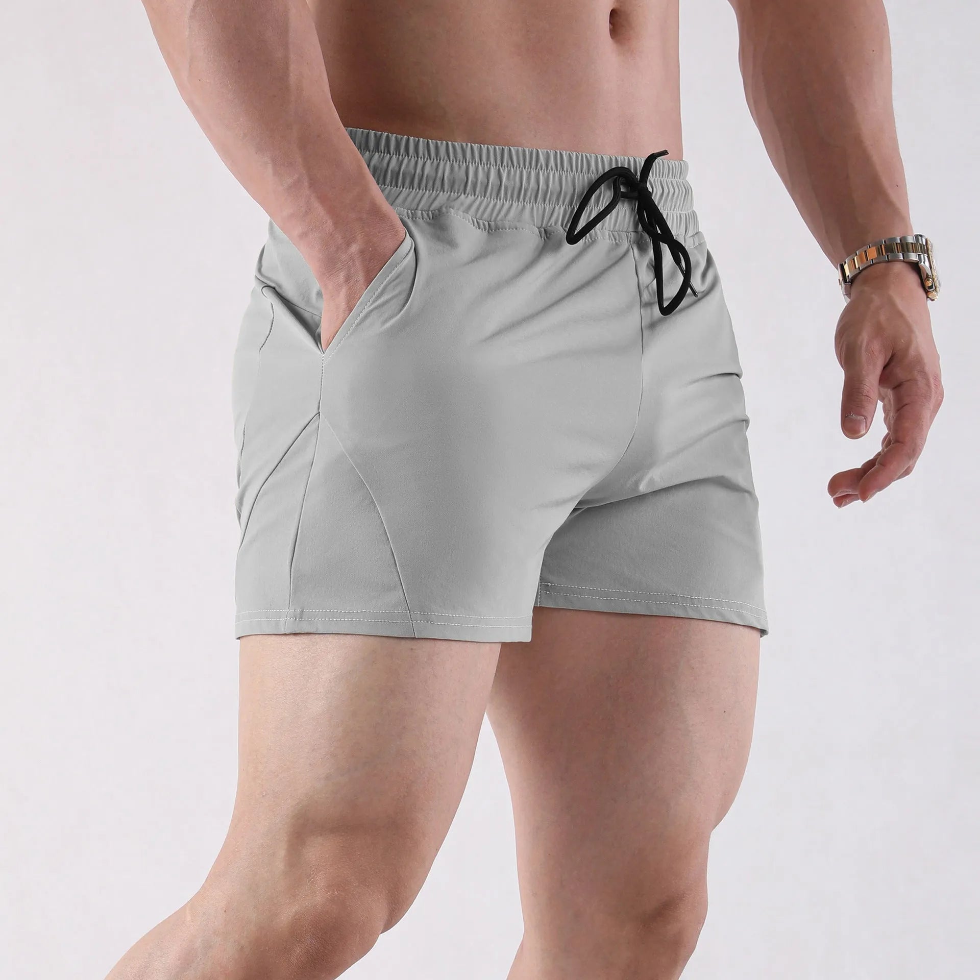 Men's thin grey polyester basketball shorts with an elastic waistband, shown in an athletic context.