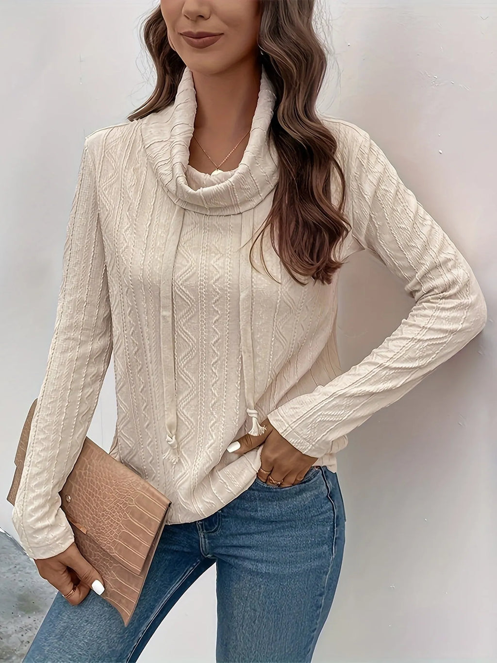 Apricot coloured pullover sweater with a drawstring hood and long sleeves laid flat.