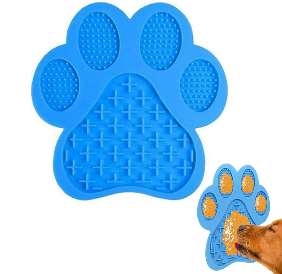 Blue silicone dog licking mat with bone-shape texture and suction cups on a tiled wall.