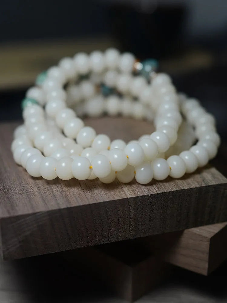 White jade bodhi seed bracelet with 108 flat round beads in 7x9mm and 8x10mm sizes.