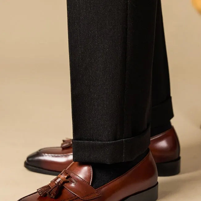 Men's black and brown tassel loafers with polished leather upper and rubber sole in British business casual style