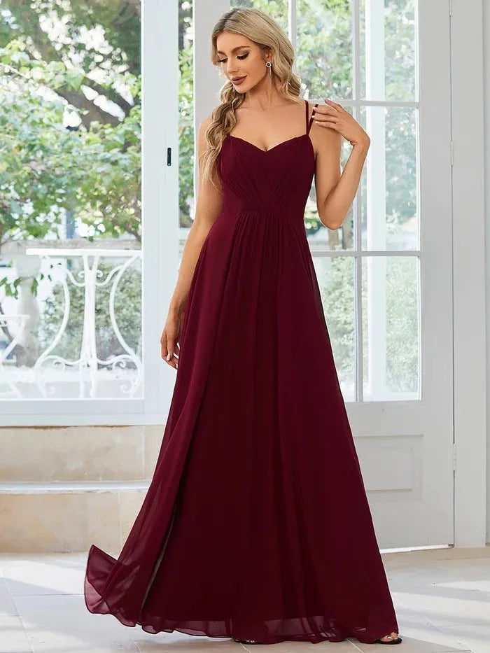 Women's light green sleeveless dress with sling neckline and long pleated A-line skirt.