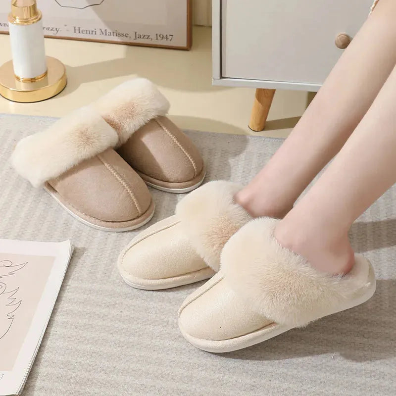 Women's brown plush indoor slippers with round toe, flat heel, and decorative stitching.