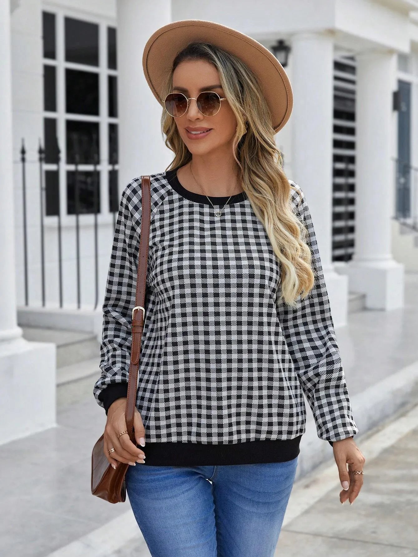 Black long sleeve pullover sweater with a striped plaid pattern and printed design detail.