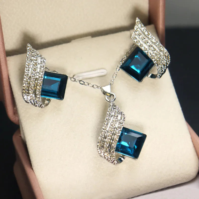 Women's cross chain necklace and earrings set with glass pendant and electroplated finish.