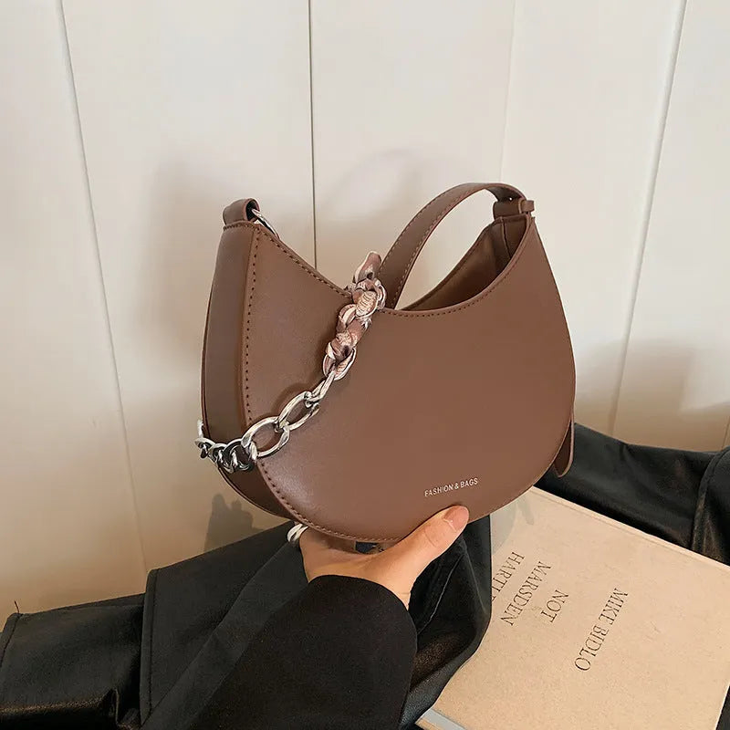 Small PU leather saddle bag on a flat surface, available in black, brown, coffee, green, khaki, and white