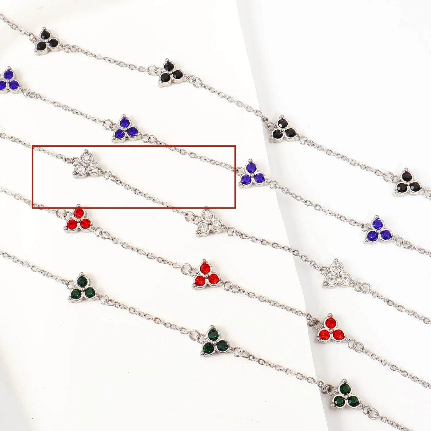 Women's stainless steel bracelet with a geometric triangle pendant, shown in gold and steel tone options with coloured stones.