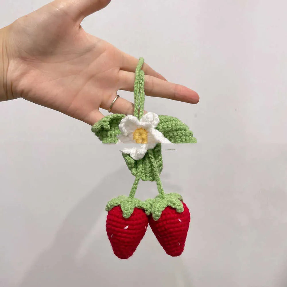 Handmade woven strawberry-shaped car hanging ornament made from cotton and hemp yarn with a Lily of the Valley hook.