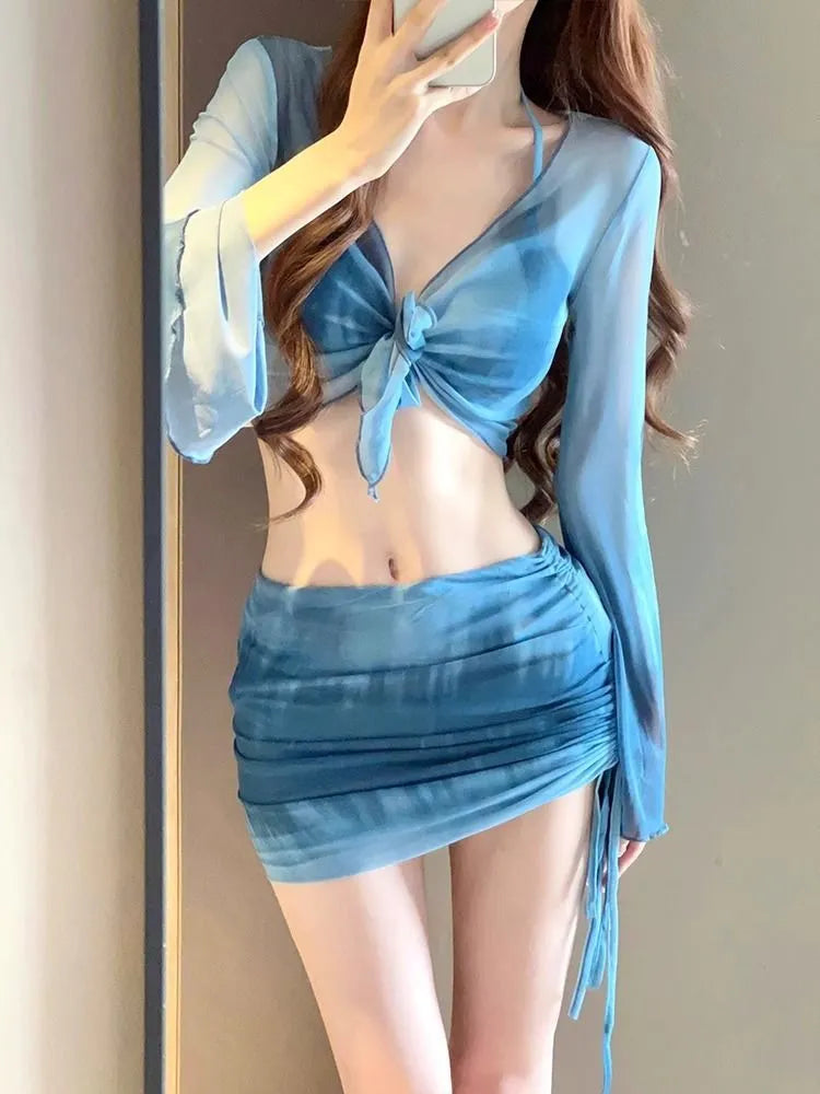 Women's blue high waist swimsuit four-piece set with shirt, bra, underwear, and skirt on beach