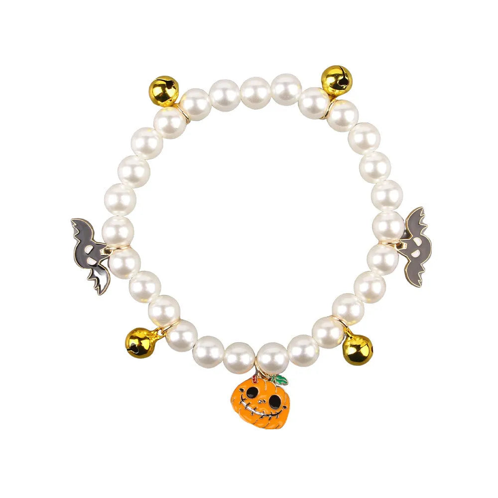Halloween cat collar with simulated pearls and pumpkin charms in purple ghost, skull, and smiling designs
