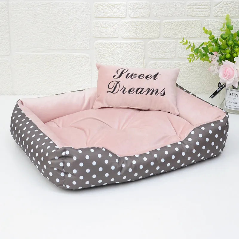 Polka dot printed square dog bed with raised bolsters and a matching embroidered pillow.