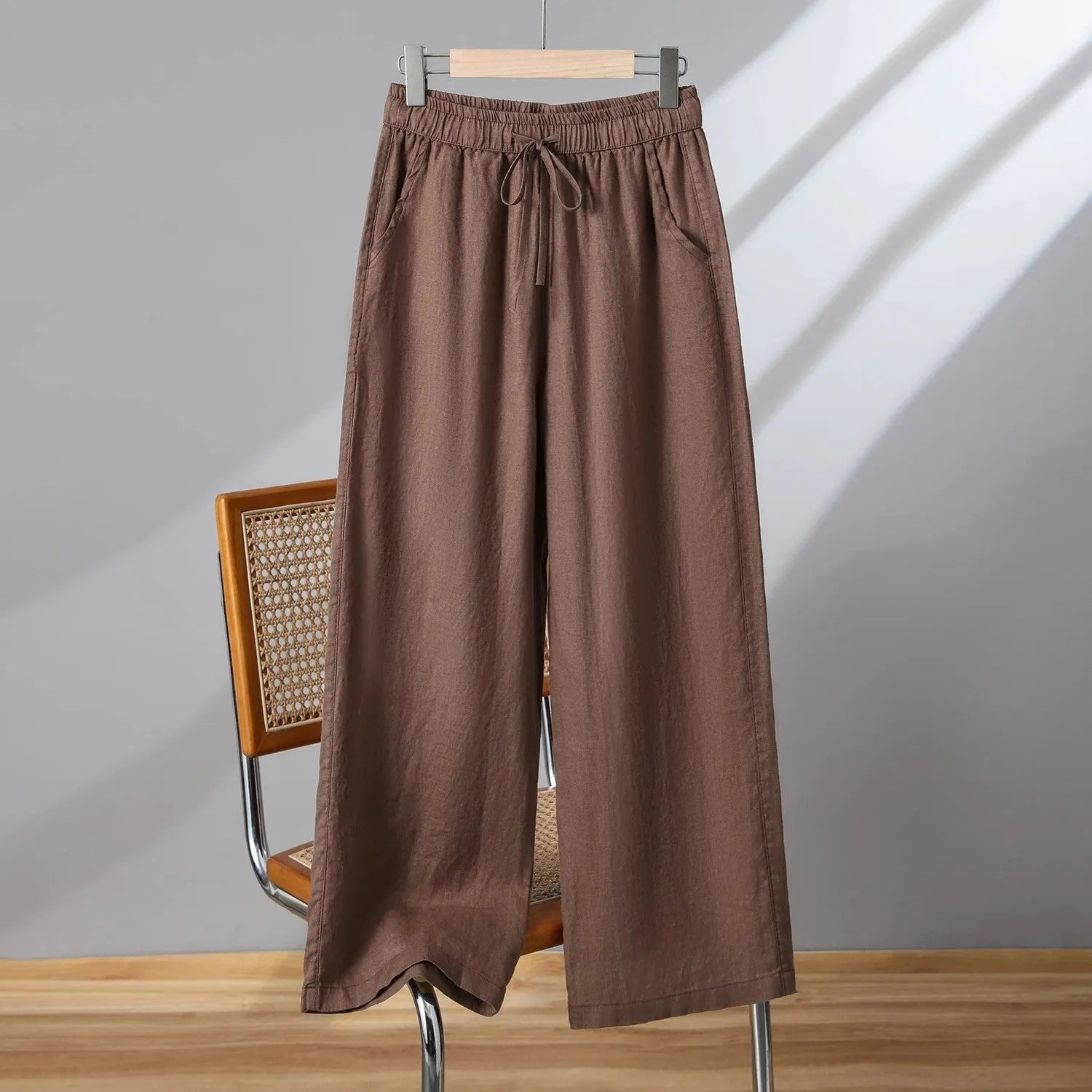 Women's apricot straight-leg casual trousers with an elastic lace-up waistband on a hanger.