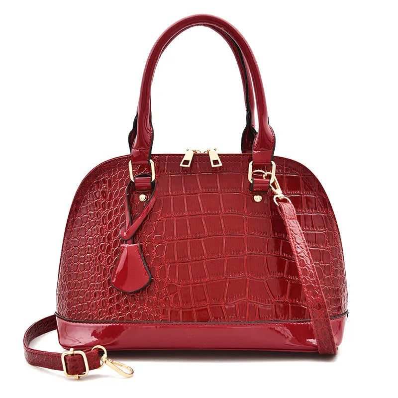 Large shiny black PU shoulder bag with crossbody strap showing interior polyester lining