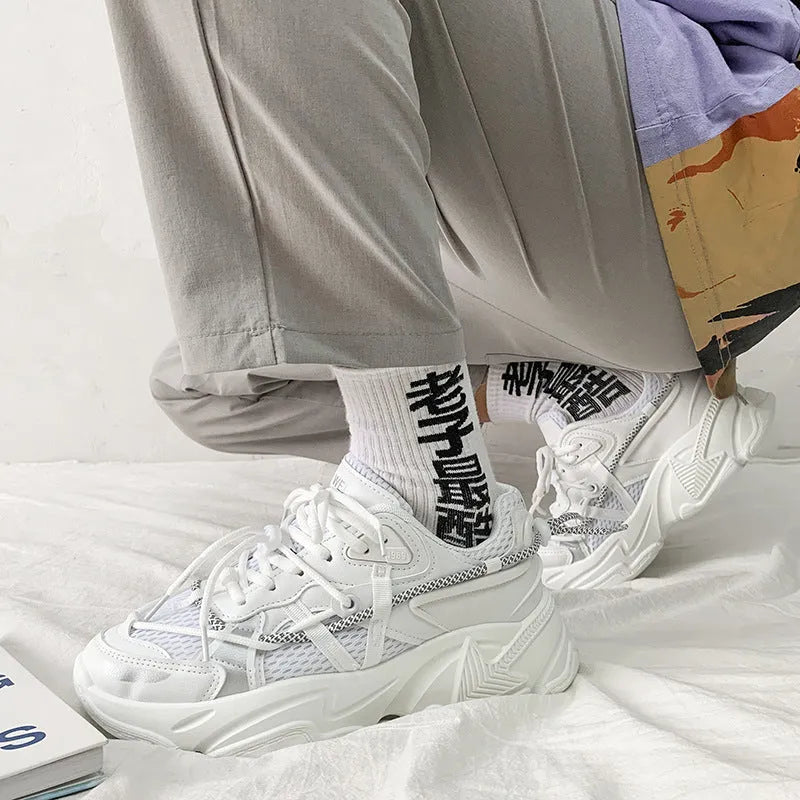 Men's black platform dad shoes with white soles and lace-up front, shown on a grey background.