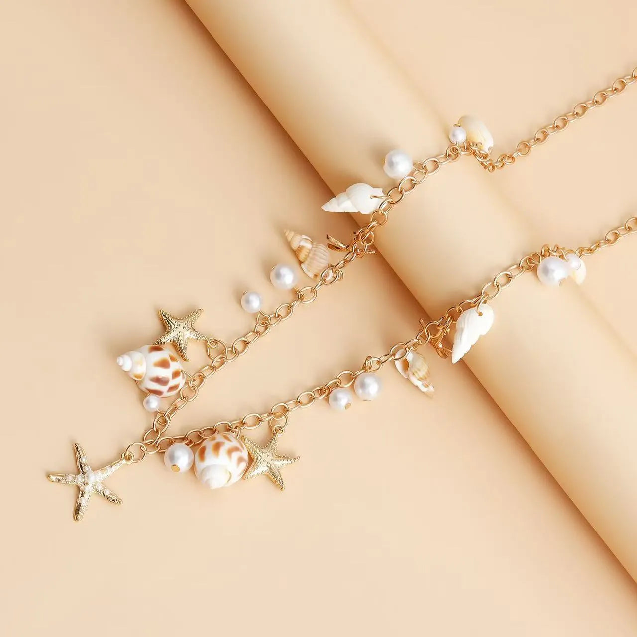 Women's alloy waist chain and matching bracelet set with star and shell design on a white background.