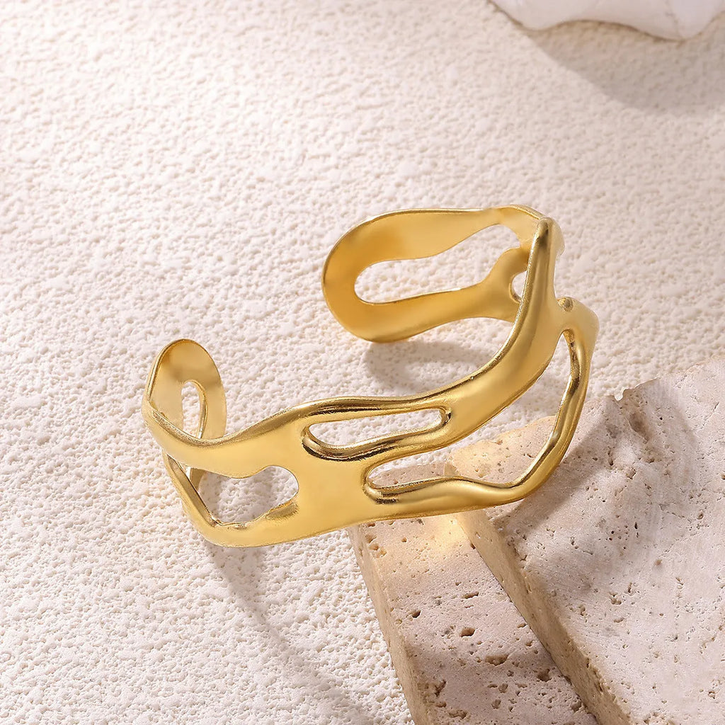 Simple irregular stainless steel gold-plated bracelet in silver finish on plain background