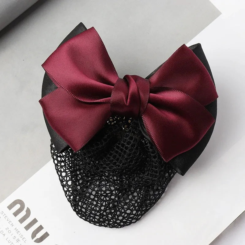 Professional hair clip with a black net pocket and a red flower bow ornament on a white background.