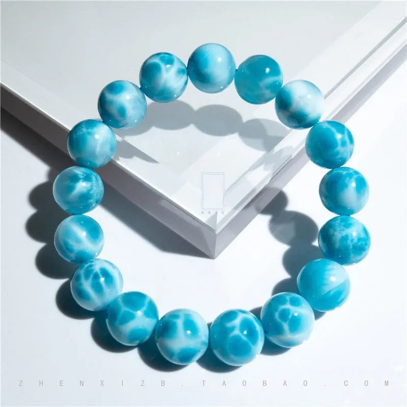 Blue handmade bodhi and pearl bracelet in Maillard style on a neutral background.