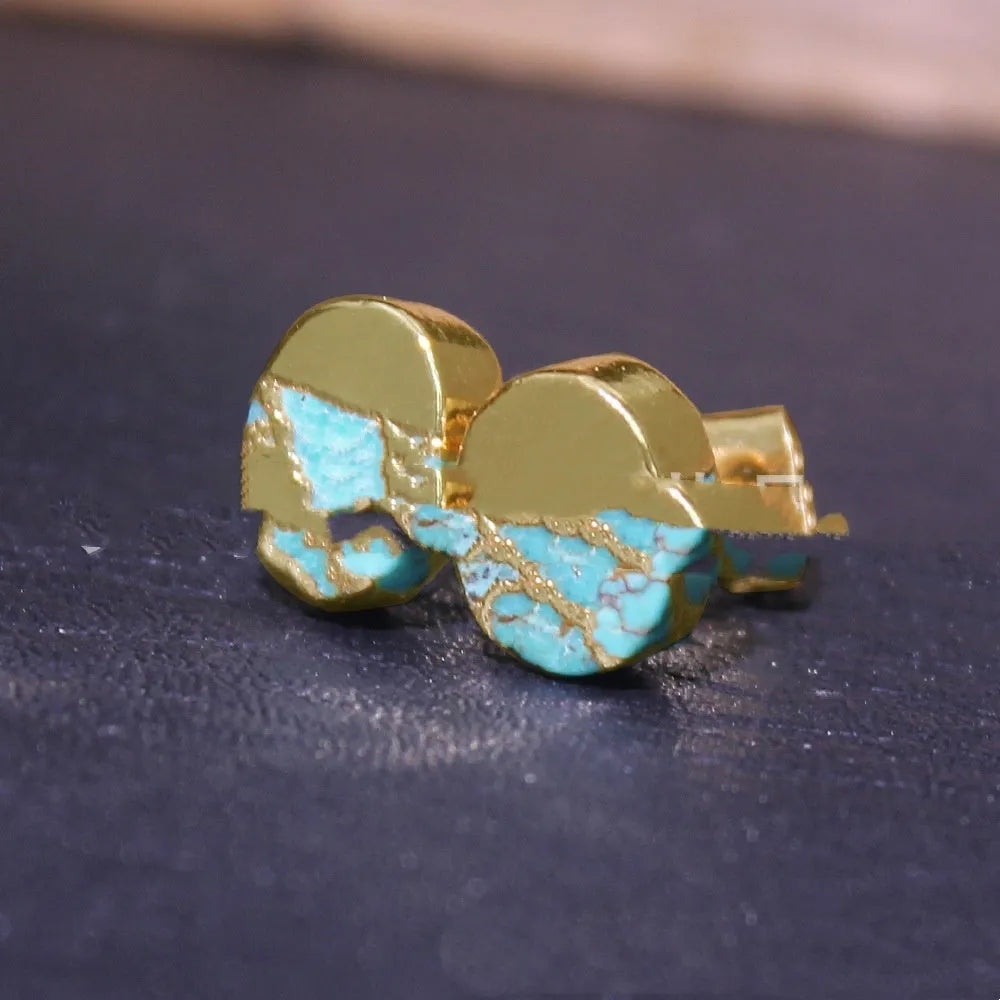 Close-up of handcrafted natural stone bohemian stud earrings with irregular shape on a plain background.