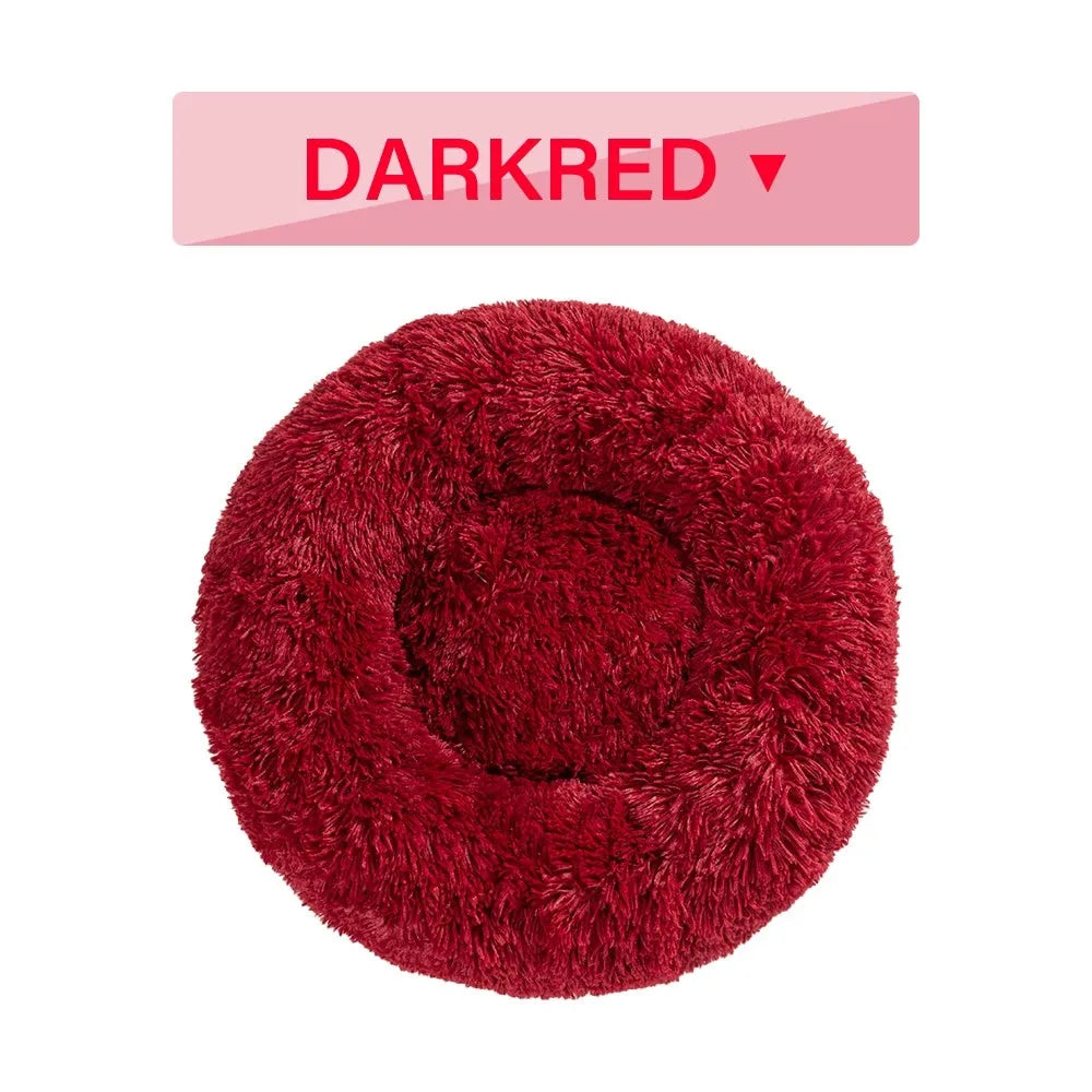 Fluffy long plush donut-shaped pet bed for dogs and cats on a wooden floor.