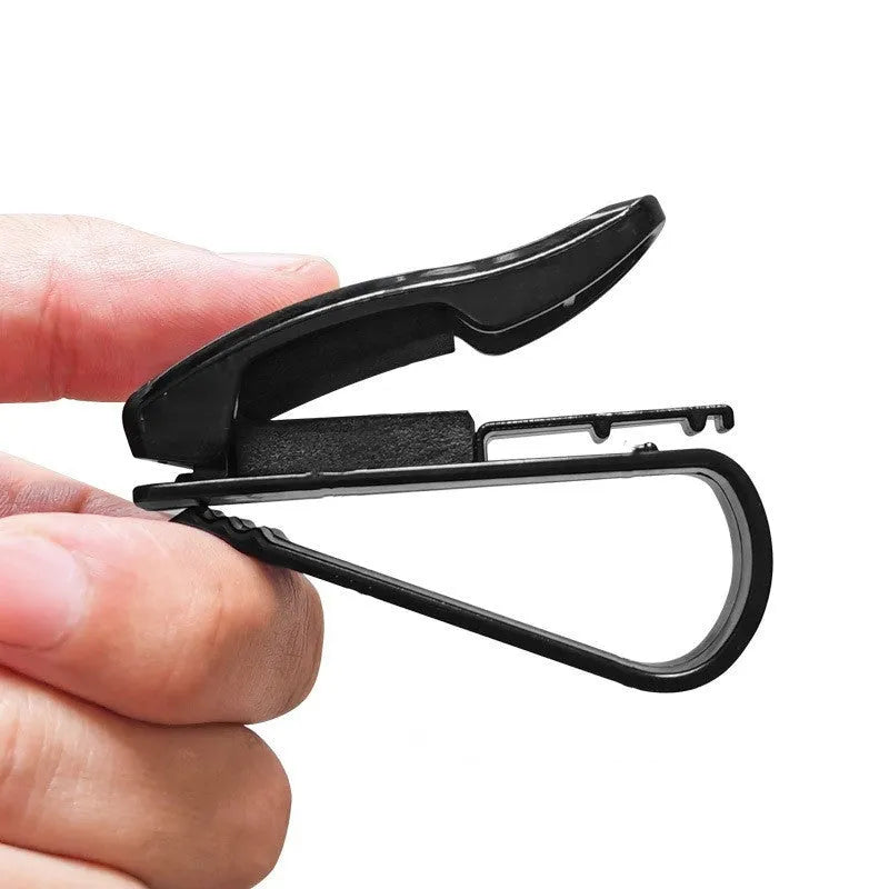 Black plastic multifunctional clip for mounting on a car sunshade to hold glasses, tickets, and ID cards.