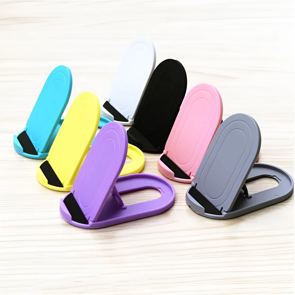 Plastic lazy bracket mobile phone stand in six colour options on a desk.